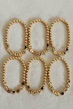 Gold Tone Ball Bead Bracelet With Black Stamped Letter Beads