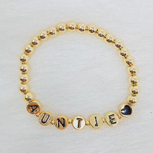 Gold Tone Ball Bead Bracelet With Black Stamped Letter Beads